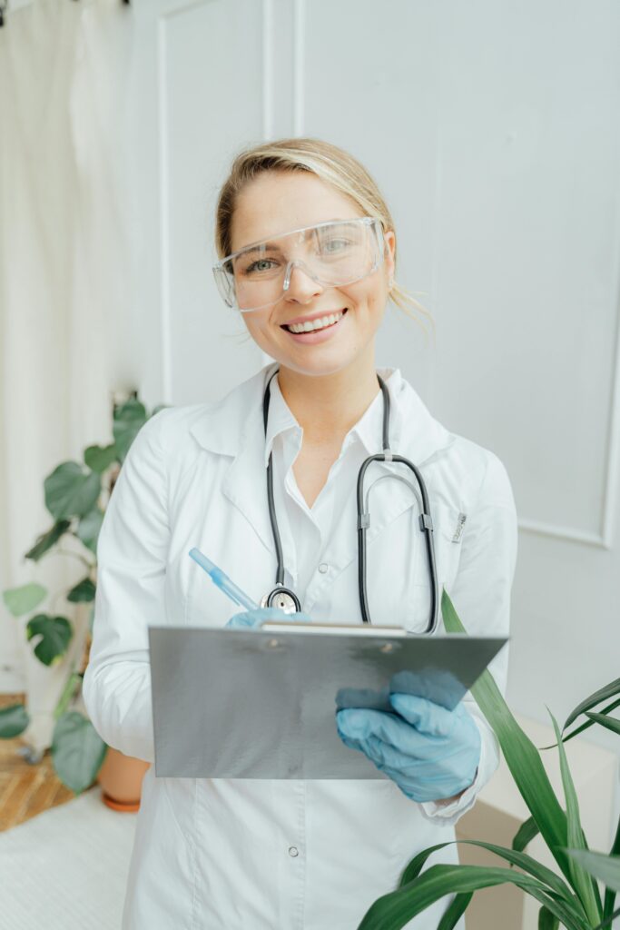 Confident female doctor with clipboard in a bright medical office.